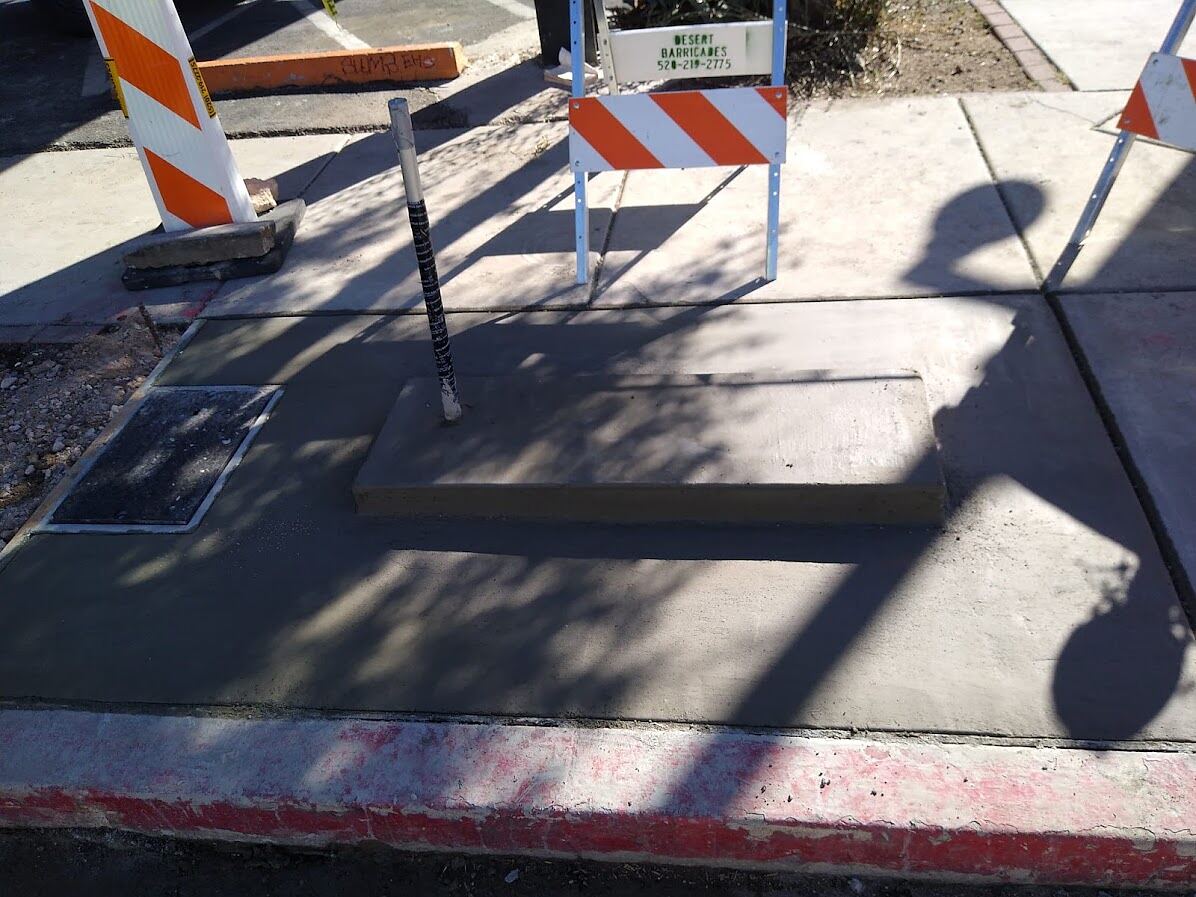 Restored sidewalk panels around a new kiosk plinth and pull box