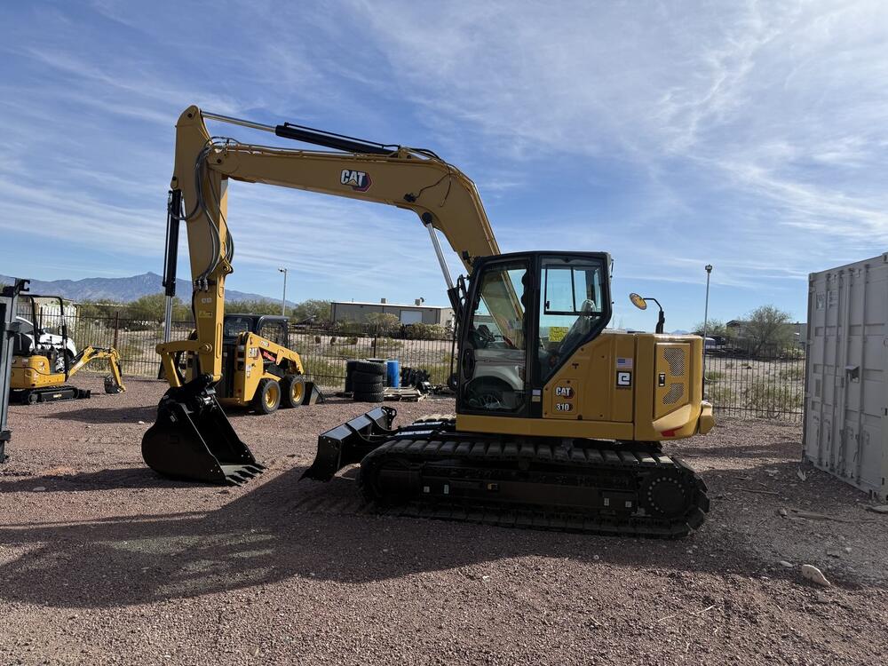 Company excavators parked on a gravel equipment yard