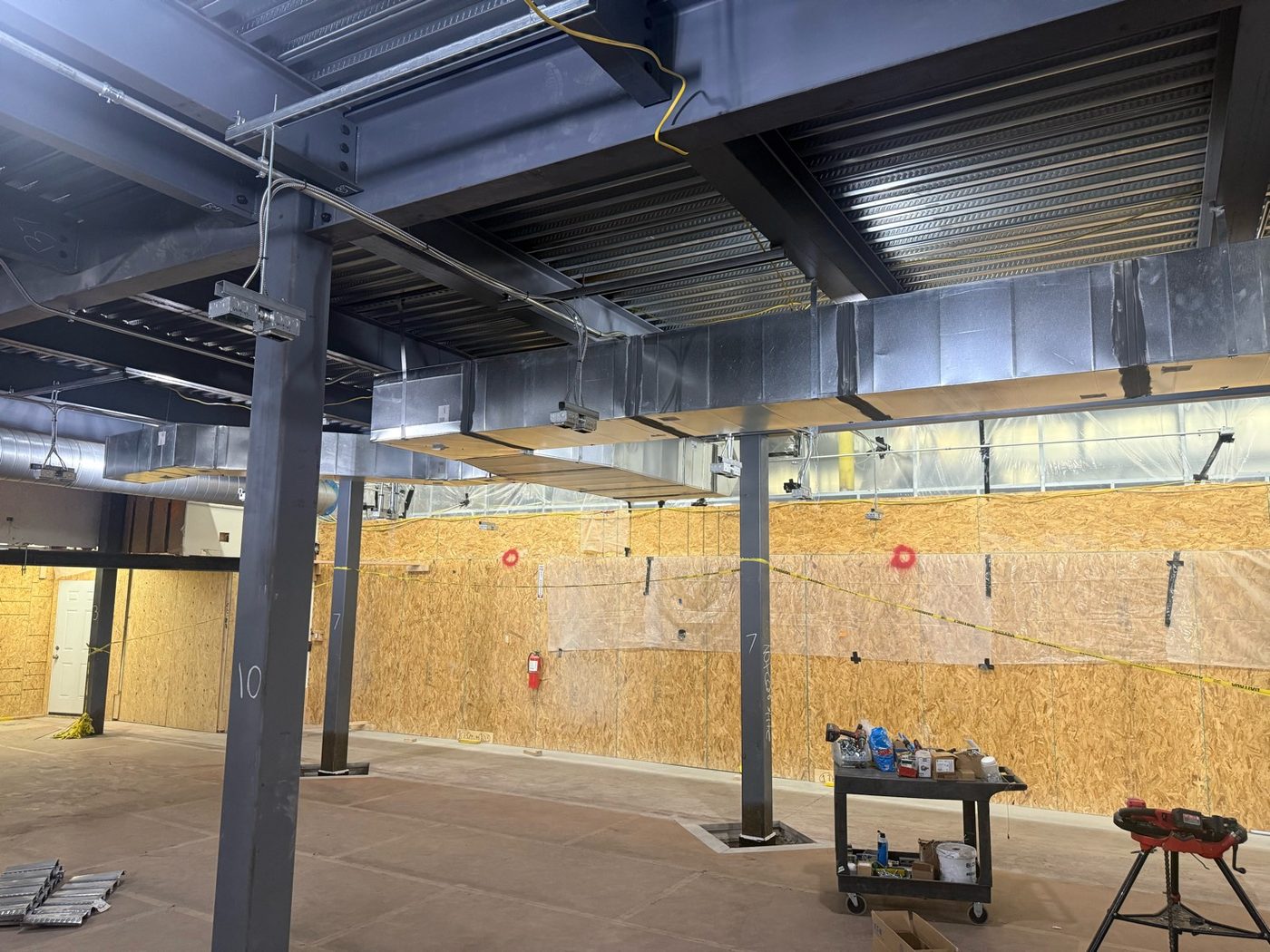 Overhead MEP rough-in with conduit racked above a ceiling grid