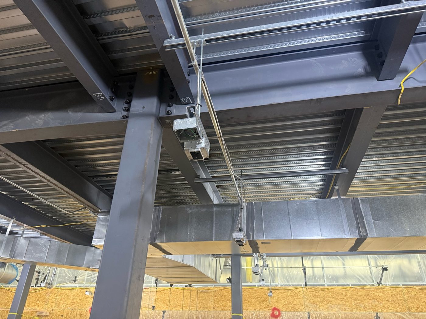 Electrical conduit and supports installed on structural steel at a commercial building